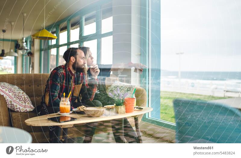 Spain, Asturias, Couple enjoying the seascape through the cafe window while having a brunch Summer Vacacion Summer Holiday Summer Holidays Joy enjoyment