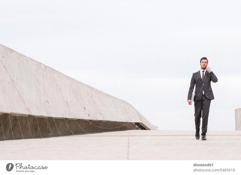 Businessman wearing black suit telephoning with smartphone Business man Businessmen Business men Surface Level worm's eye view telecommunication