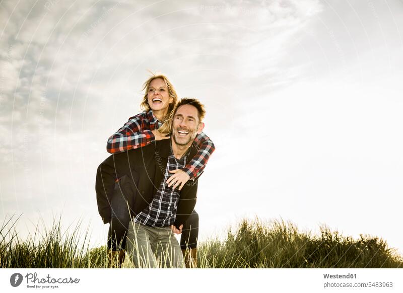 Happy playful couple in dunes laughing Laughter twosomes partnership couples sand dune sand dunes positive Emotion Feeling Feelings Sentiments Emotions