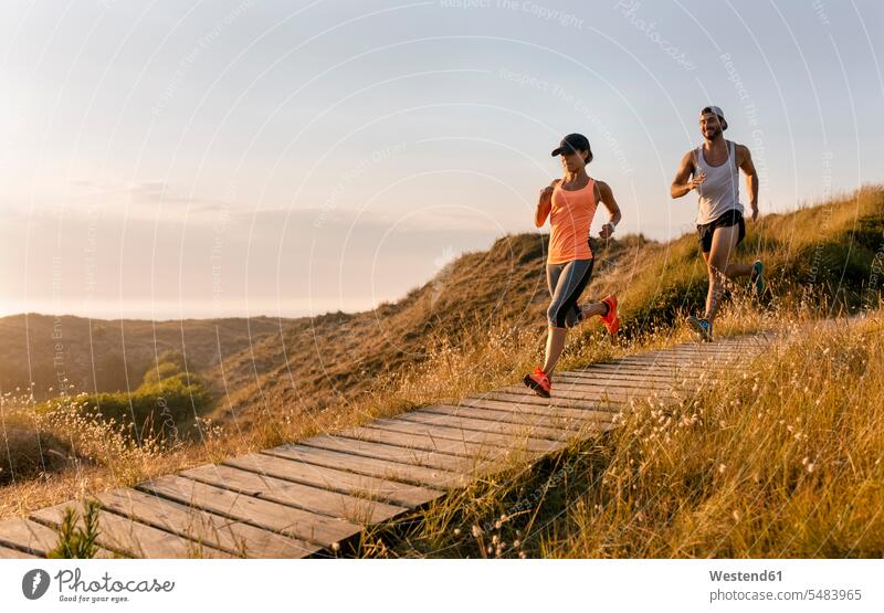 Spain, Aviles, young athlete woman running along a coastal path