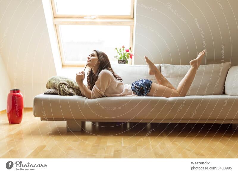 Relaxed woman lying on couch females women settee sofa sofas couches settees laying down lie lying down Adults grown-ups grownups adult people persons