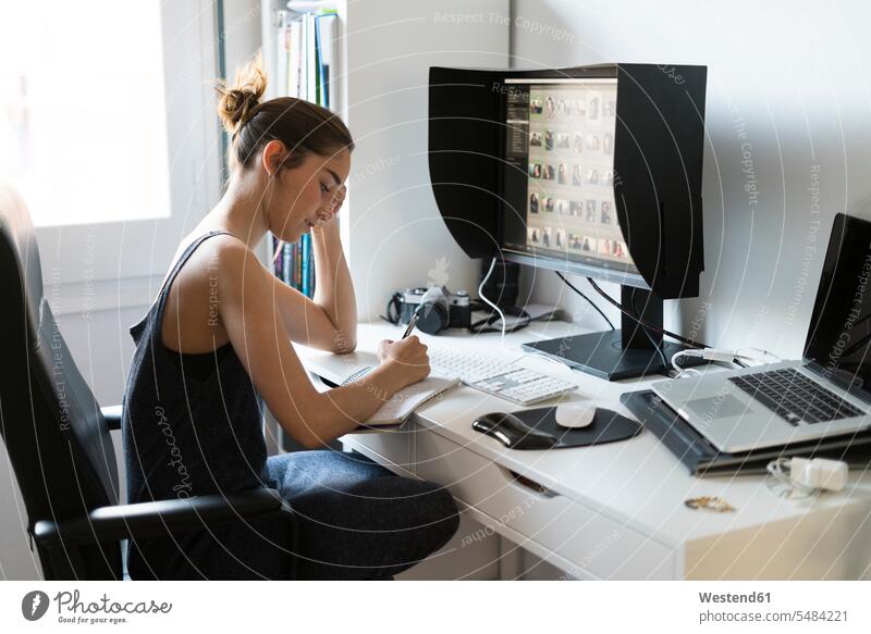 Female photographer editing images at desk screen screens monitor monitors woman females women female photographer photographs photos Adults grown-ups grownups