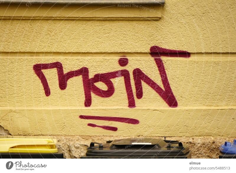 MOIN is written in burgundy art lettering on a wall in front of which trash cans are placed month Salutation salutation Greeting Good day! Have a nice day