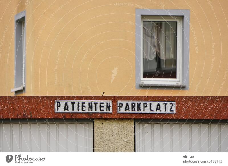 two signs PATIENTS and PARKING PLACE on a functional building in front of a residential building Parking lot Patient parking medical practice Apartment Building