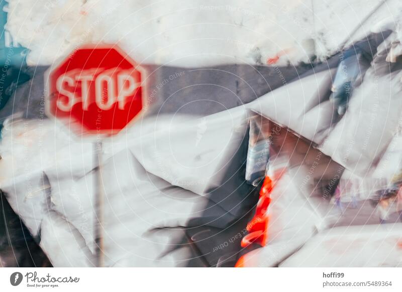 Vibrating stop sign in front of a torn billboard Stop sign Stop signal Hazy vibrating Uncertain future hazy Ambiguous Fear of the future problems depression