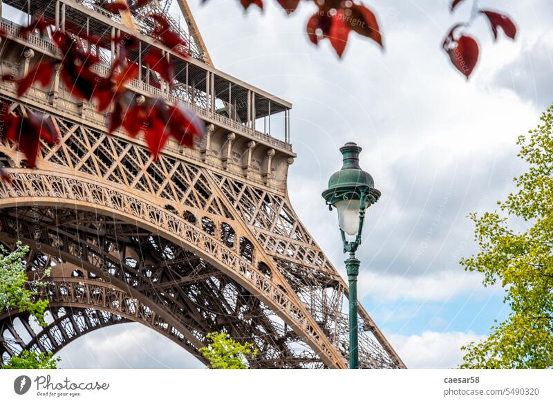 View of the Eiffel Tower in Summer, Paris paris building light leafs street light eiffel tower tour eiffel construction iron red architecture close up