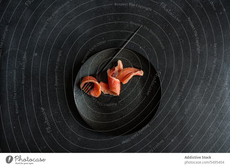 Healthy salmon slice on dark plate dish healthy food black dark background table surface yummy fresh nutrition nutrient fork menu darkness high angle from above