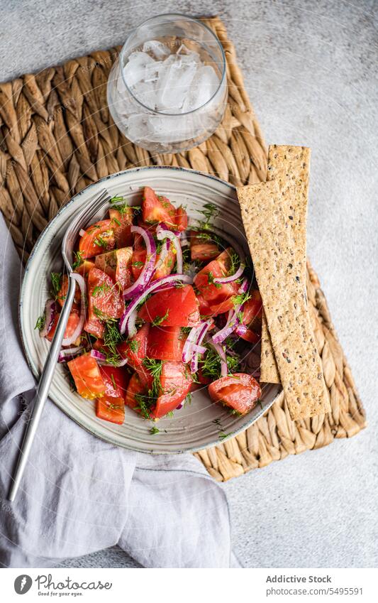 Bowl of salad with crusty bread and glass with ice bowl tomato onion herb ingredient fresh vegetarian food vegetable meal dish portion dill nutrition natural