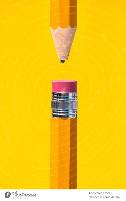 Sharpened broken tip and eraser at top pencils placed together on yellow backdrop color composition stationery tool ring set wooden bright colorful draw red