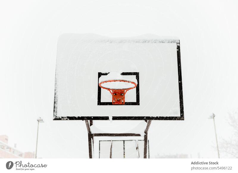 Basketball hoop on sports ground in town hang basketball winter activity game snow neighborhood streetball facade dwell building training public housing play