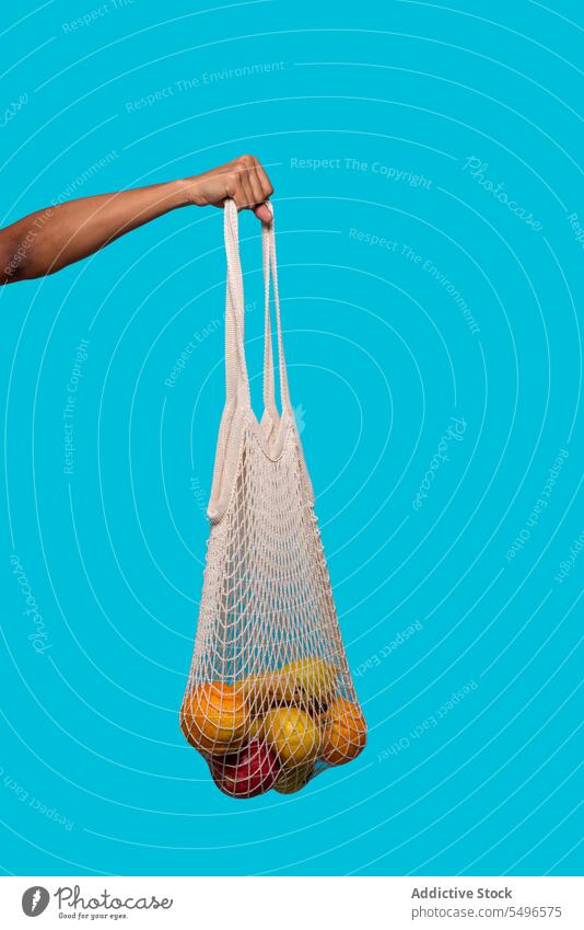 Crop person holding reusable net bag with fruits hand eco friendly zero waste ecology healthy shopping bag mesh bag string bag ecosystem fresh natural organic