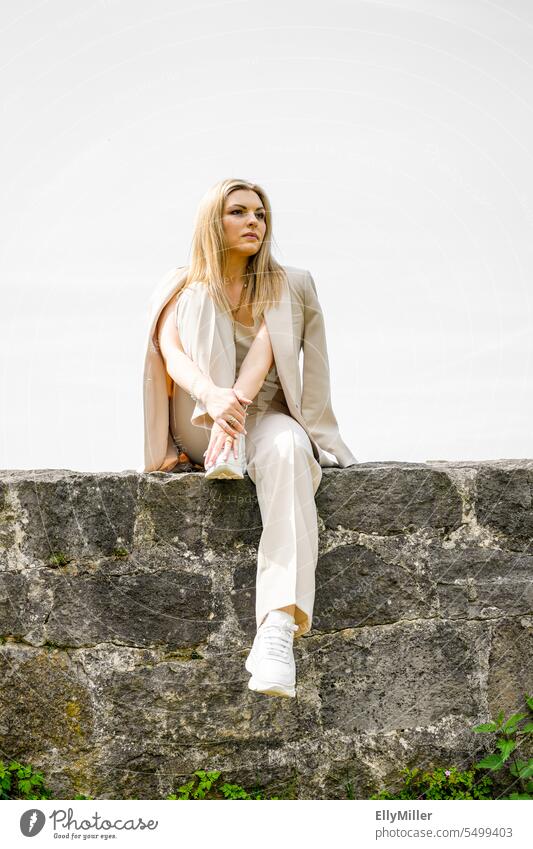 Young woman sitting on a wall. Woman Wall (barrier) Lifestyle free time youthful Blonde Ponytail Joy portrait Happy relaxed Relaxation pretty Attractive