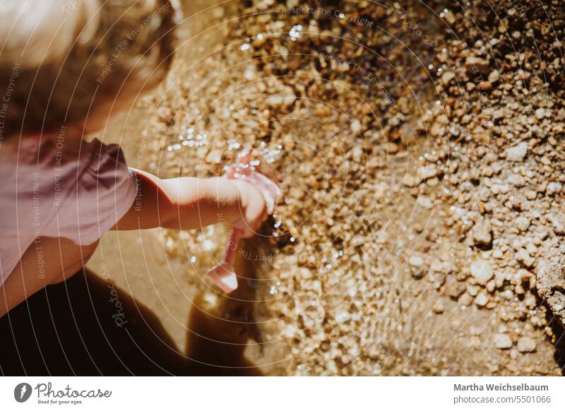 Child playing in stream with sand and gravel Sand game Playing outdoors playing in nature Playing in the stream Nature Playing with water Brook Water Outdoors