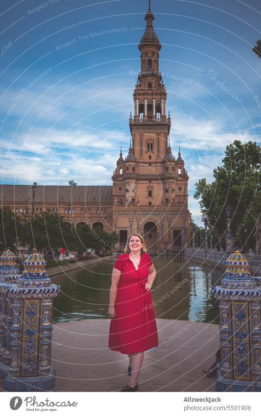 Middle aged woman with blonde hair and red dress in Plaza de España Spain Andalucia Seville Woman Dress Water Blonde vacation Vacation photo pose posing