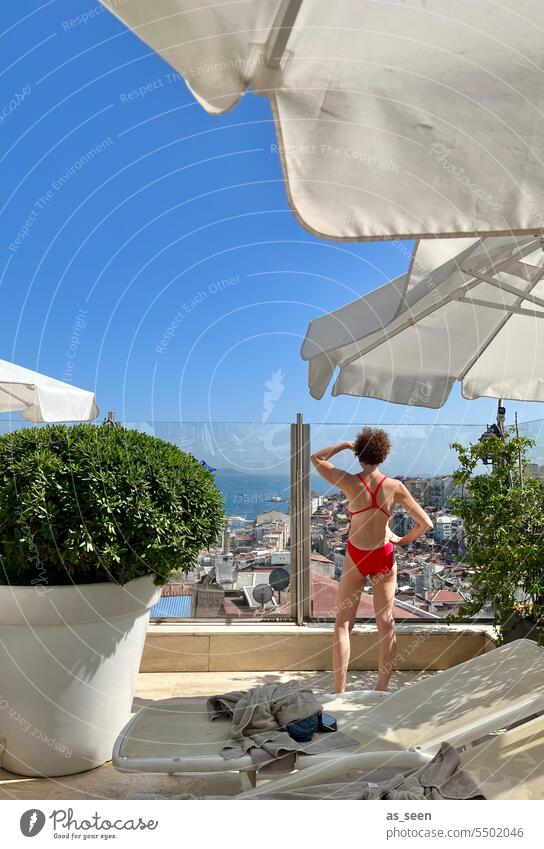 Woman looks at Istanbul Swimsuit Vantage point Red The Bosphorus parasols deckchairs Hotel Beech Pane Summer Blue sky vacation Relaxation Vacation & Travel Sky
