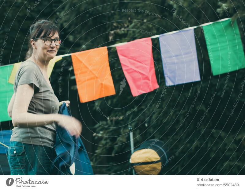 Drinkje bej Inkje | erect tent - woman standing in front of a large garland and holding a tent in her hand variegated Party camping celebrations Paper chain