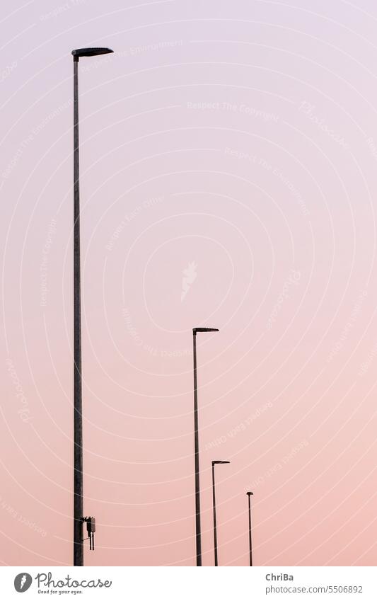 Street lamps in evening light street lamps Homogeneous graphically Equal Light Abstract Dark Sky Exterior shot Red Deserted Architecture darkness Lamp Evening