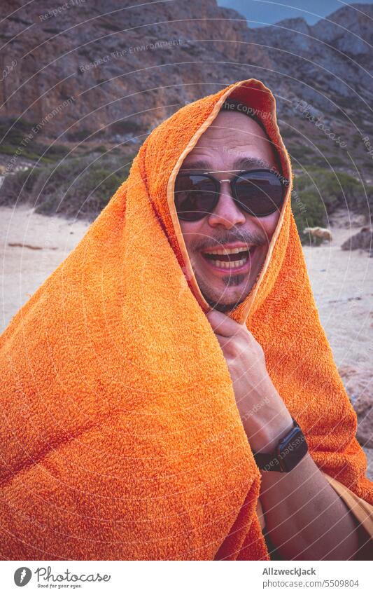 Middle aged man with sunglasses sits on beach wrapped in towel and laughs Summer Summer vacation Vacation mood Vacation photo Summery Summer's day Beach