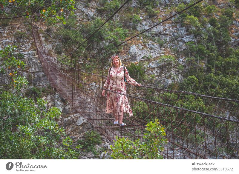 blonde middle-aged woman with dress on old suspension bridge in Podgorica, Montenegro Blonde blonde hair Middle aged woman Dress vacation Vacation mood Hiking