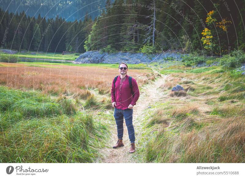 Middle-aged man with sunglasses and red shirt stands in nature in Montenegro vacation Vacation mood Nature Nature reserve Hiking Relaxation Meadow Grass wide