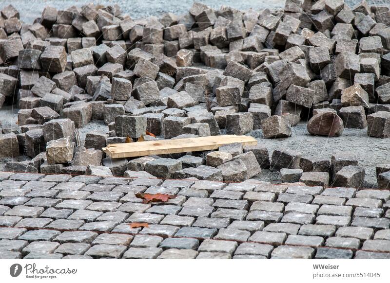 A square is laid out with paving stones in neat rows Stone Ground Places forecourt Roadworks Construction site Build labour series Muddled Arrangement Sheepish