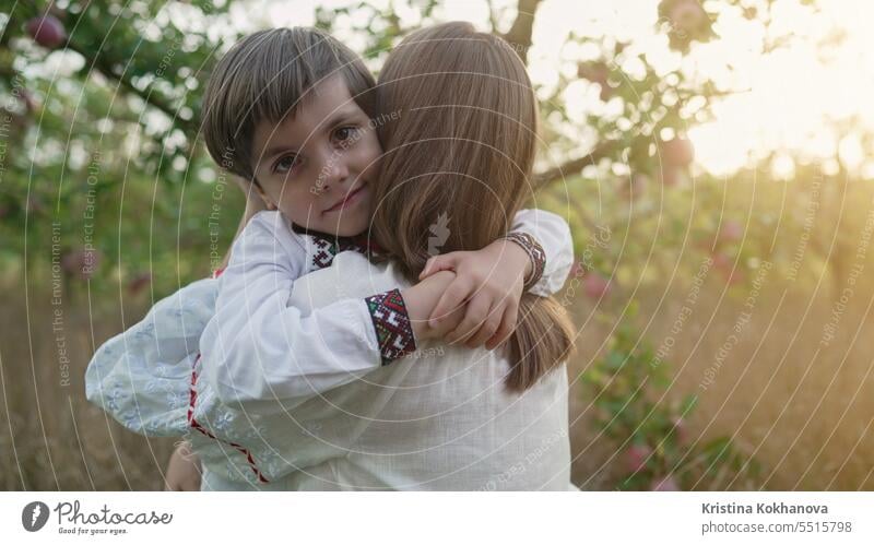Portrait of beautiful family - 4 years old boy and mother in apple garden. mom son happy hug love parent care happiness hugging motherhood parenthood smiling