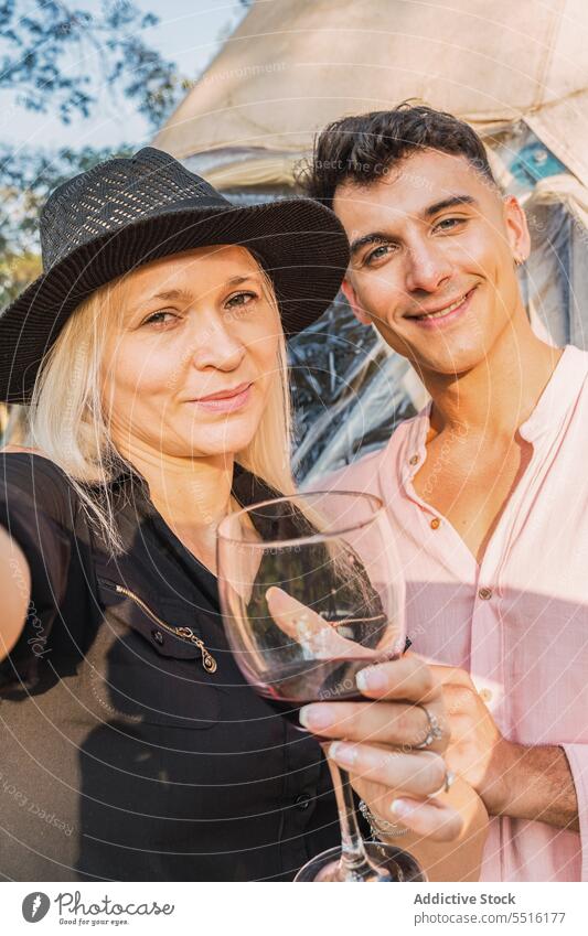 Woman taking selfie with smiling friend woman vacation party wineglass happy nature weekend alcohol countryside meeting style together rest drink take photo
