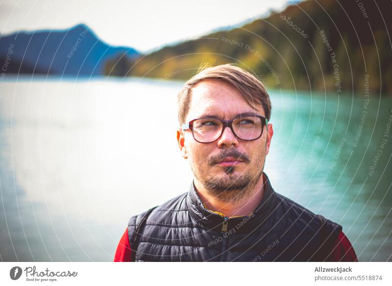 Portrait of a peculiar looking middle-aged man with glasses at a lake portrait Man Eyeglasses Person wearing glasses Face Expression Skeptical Thinking