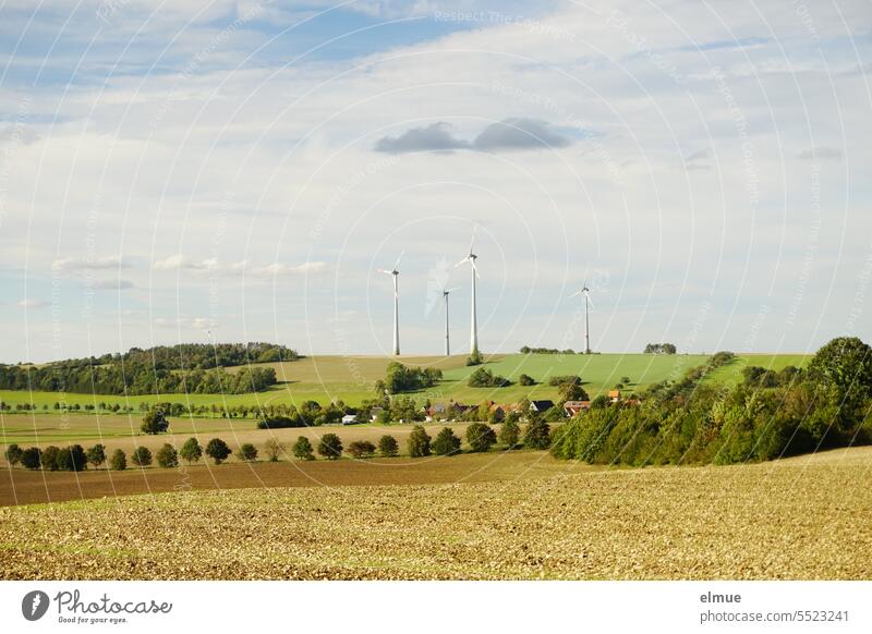 Wind turbines in hilly landscape with trees and harvested fields / early autumn windmills Landscape wind power Renewable energy hilly country Field