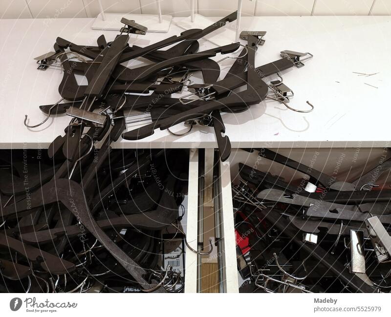 Black plastic clothes hangers on a white shelf next to the changing room in a shopping center in Erenköy in the Sahrayicedit and Erenköy district of Istanbul on the Bosphorus in Turkey