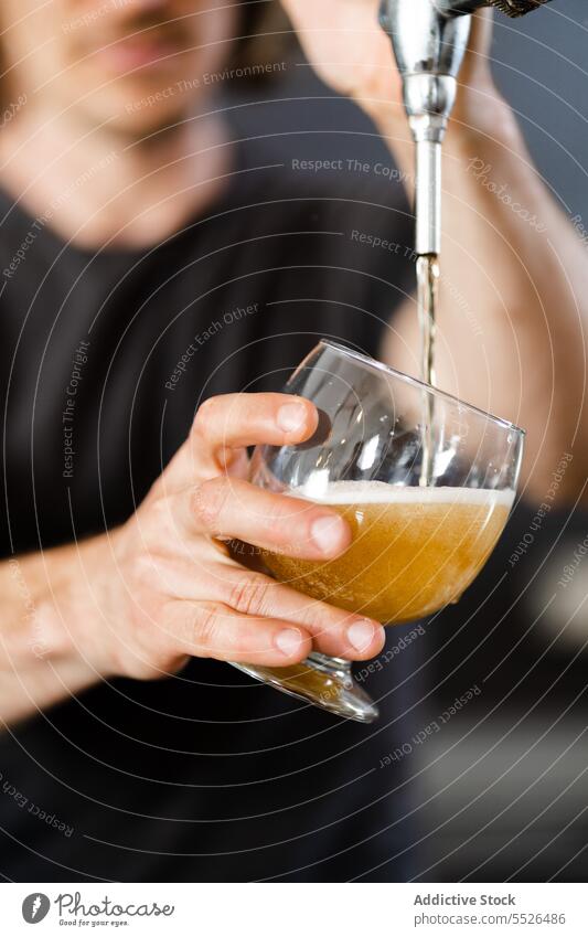 Crop unrecognizable young man standing and pouring beer from tap into glass open alcohol beverage transparent drink male interior liquid casual alone fresh guy