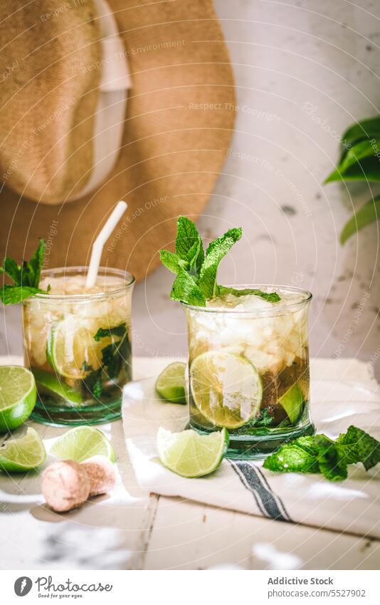 Fresh mojito in glass served with ice lime cava peppermint brown sugar napkin table cocktail beverage drink leaf herb alcohol liquor ingredient fruit citrus