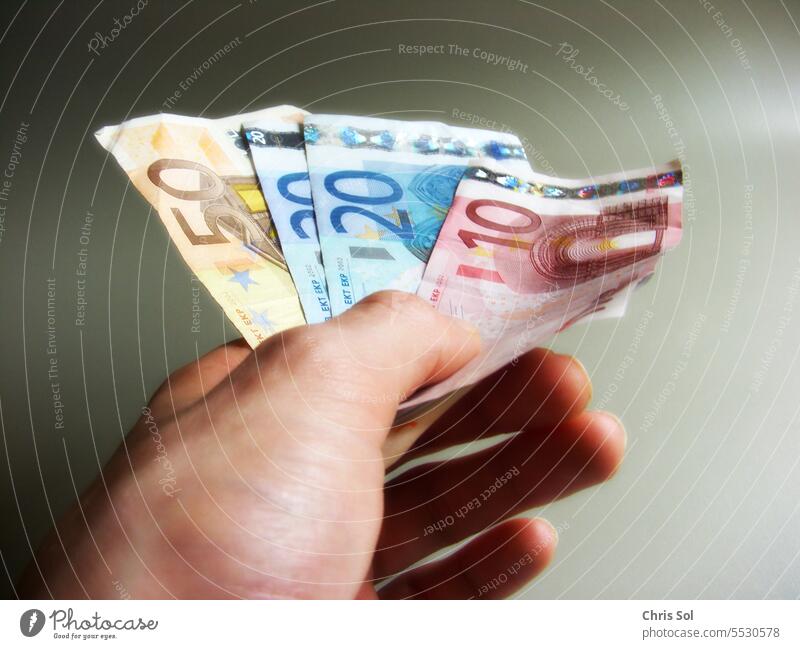 100 Euro money bills 50 €, 20 € ,10 € - cash money bills fanned out in one  hand - a Royalty Free Stock Photo from Photocase