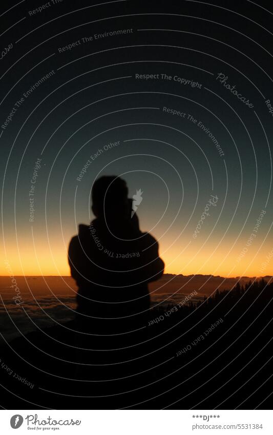 Man filming sunset on mountain above clouds with cell phone Sun Silhouette Horizon silent Moody Sunrise Sunset Black Contrast Yellow Evening Orange person Light