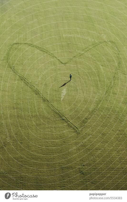 Welcome - aerial view of a very large heart drawn on a meadow. In the middle of the heart is a person, probably the person who drew the heart! Heart Sincere