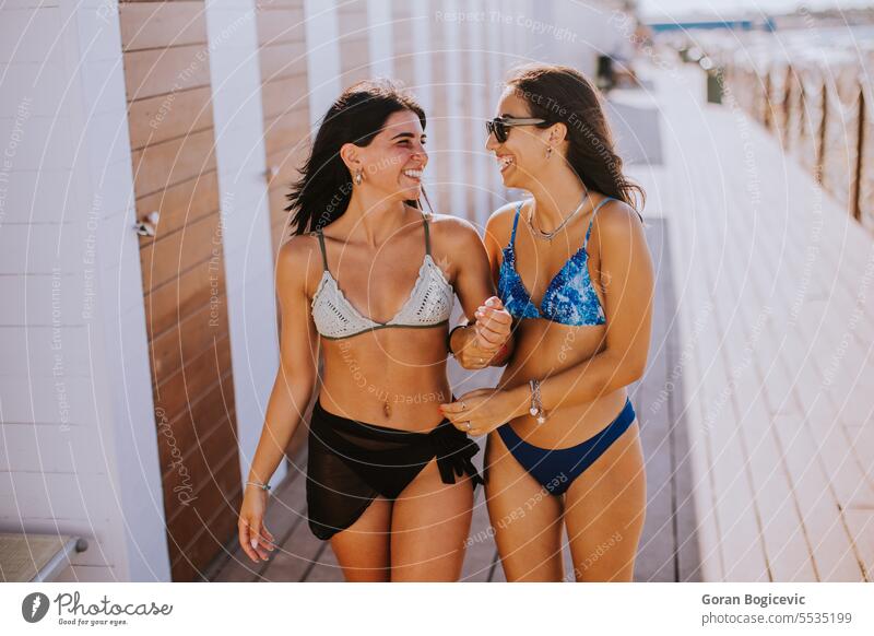 Smiling young women in bikini enjoying vacation on the beach adult attractive caucasian clothing day emotion fashion female friends friendship fun girlfriends