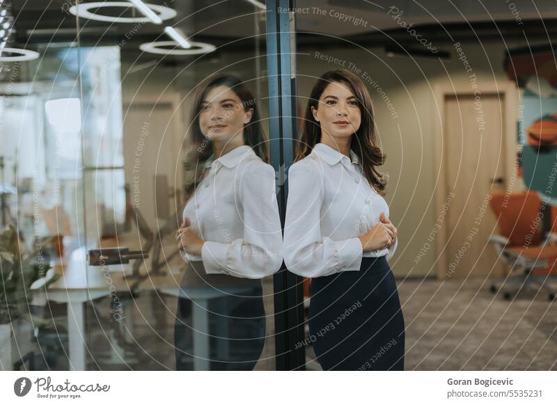 Young business woman standing with arms crossed in the modern office employee businesswoman manager portrait leader professional executive female smiling work