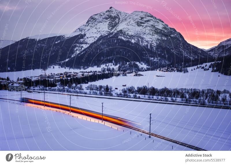 Magnificent view of snowy mountains and train against sunset sky rail rock weather highland idyllic Switzerland ridge transport majestic cloud dusk breathtaking