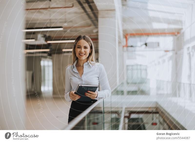 Smiling elegant confident middle aged woman standing in office