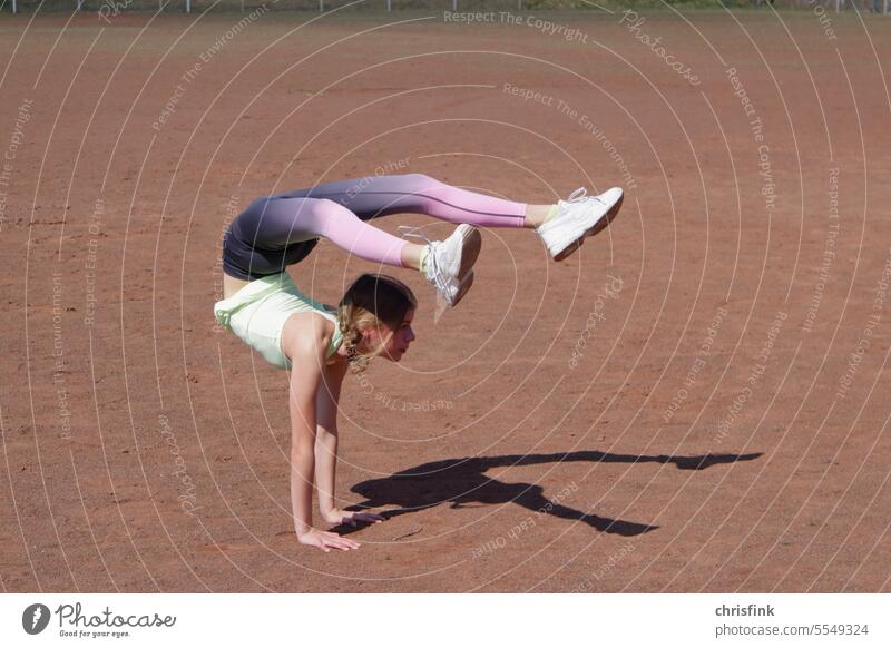 Gymnast on sports field in pose Gymnastics gymnastics bend contorsion Mobility Shadow Sporting grounds youthful Beauty & Beauty Youth (Young adults) Fitness