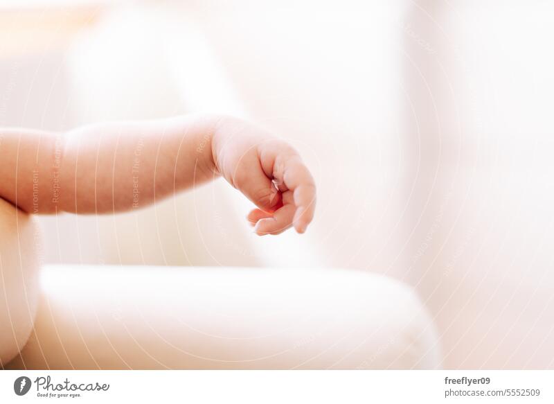 detail of the hand of a newborn in studio lighting against white baby firstborn portrait laying laying down copy space parenthood motherhood innocence life