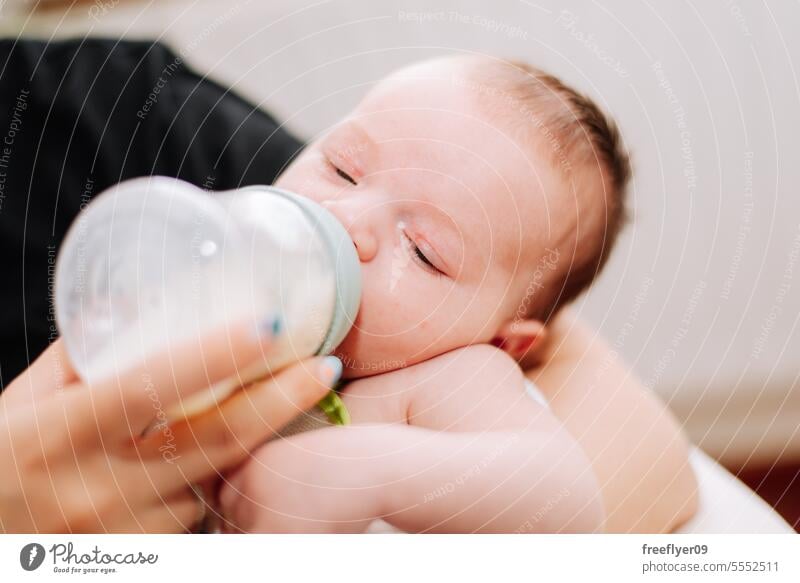 portrait of a newborn drinking from a feeding bottle baby food parents children son adorable care love family confident father milk happy fatherhood adult