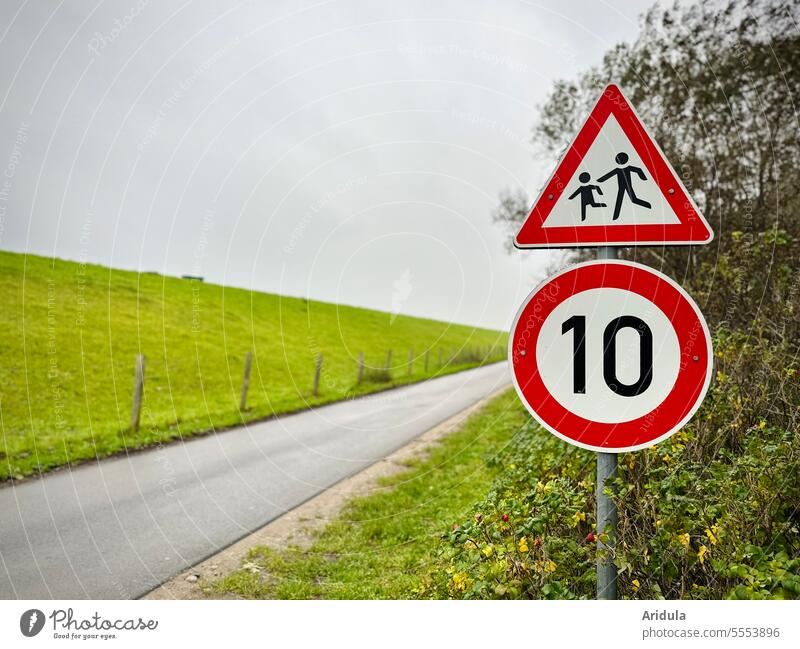 Attention children! and 10 km/h | Signs on a road on the dike Road sign Street Dike tempo esteem Warning sign Signage Road traffic Signs and labeling Safety