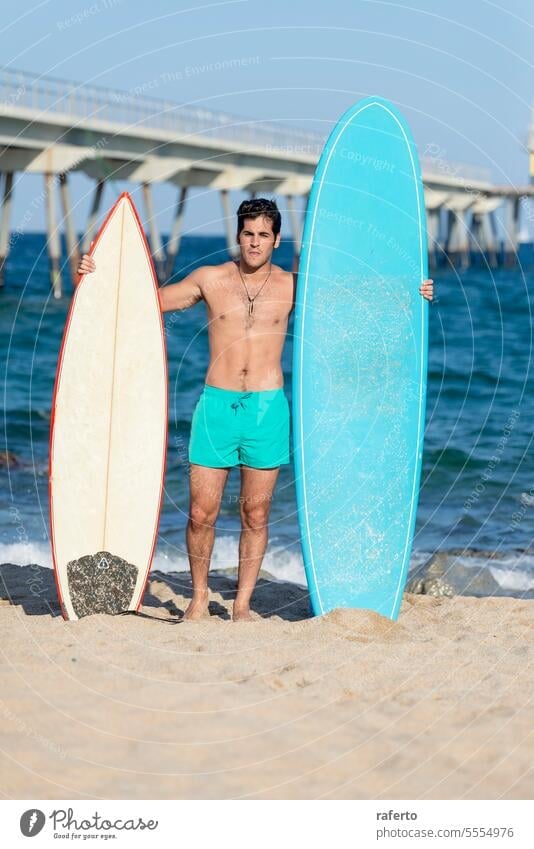 Young handsome man with a surfboard at a beach summer surfing male sport ocean leisure water outdoor sea sand surfer lifestyle standing person active holding