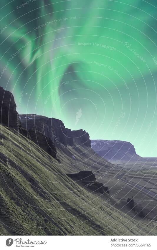 Majestic sky with northern lights over rocky cliffs mountain traveler nature cold aurora borealis range adventure highland landscape green admire formation
