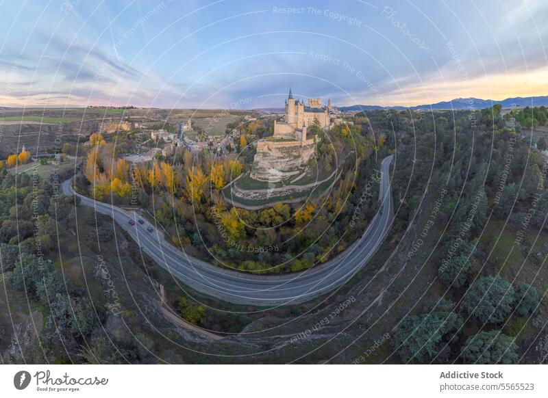 Drone view of castle city highway green and autumn trees in daytime building cityscape architecture ancient hill historic construction exterior road street