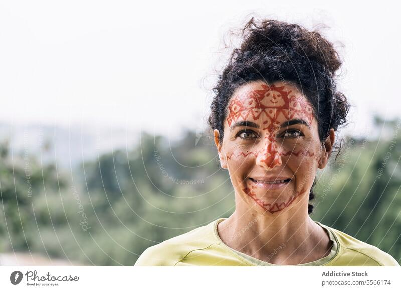 Smiling mature female with painting on face woman smile nature forest happy green traditional casual glad positive fun optimist content leisure alone pleasant