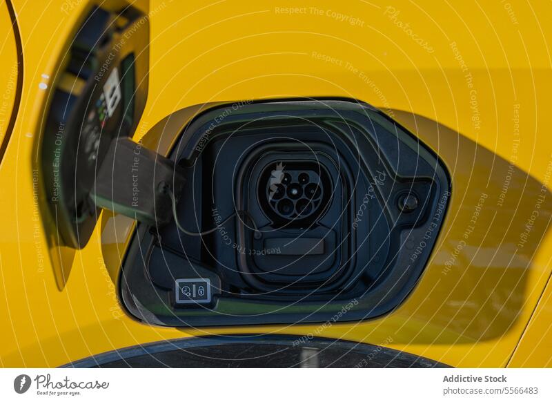 Charging port on yellow electric vehicle connector plug car close-up energy EV transport power socket green technology charger modern eco-friendly connection