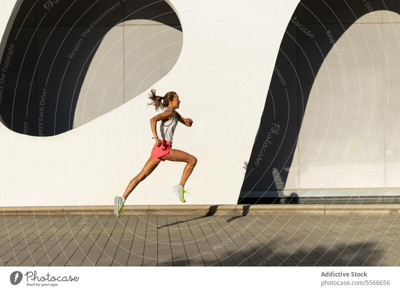 A woman running down a sidewalk in a city - a Royalty Free Stock Photo from  Photocase