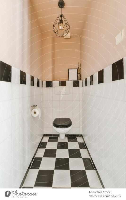 Small tiled bathroom with toilet seat floor bidet pendant clean black white wall ceiling modern apartment design house interior home style contemporary empty